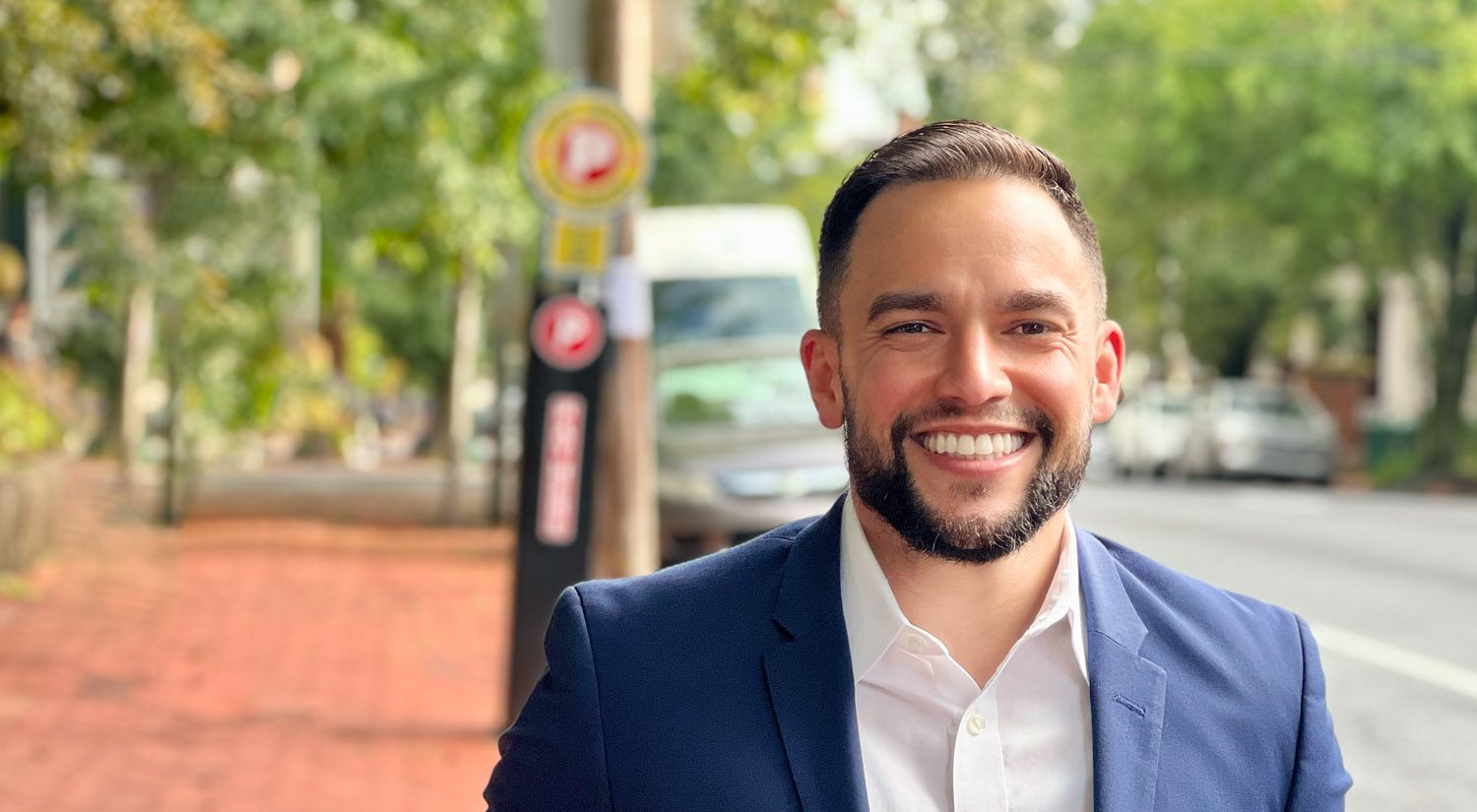 A man in a suit smiling for the camera.